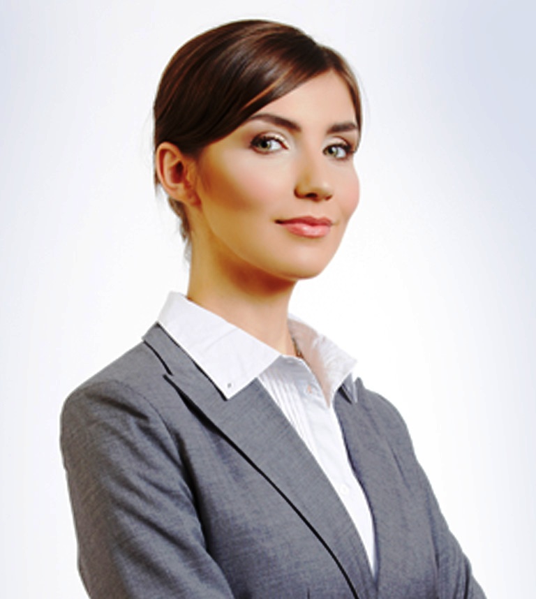 Confident businesswoman in a gray suit smiling at the camera.