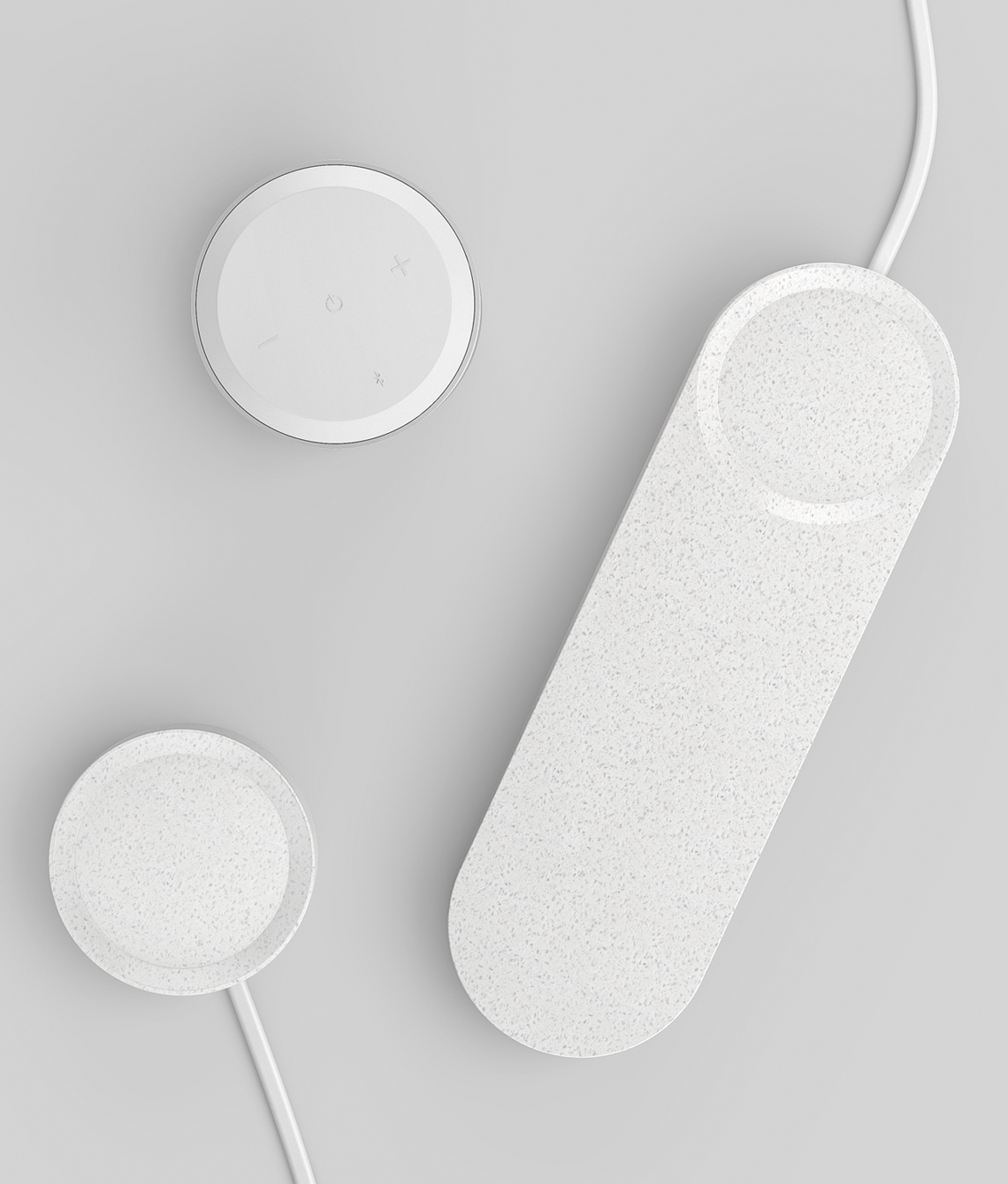 Three white smart speaker devices on a light surface.