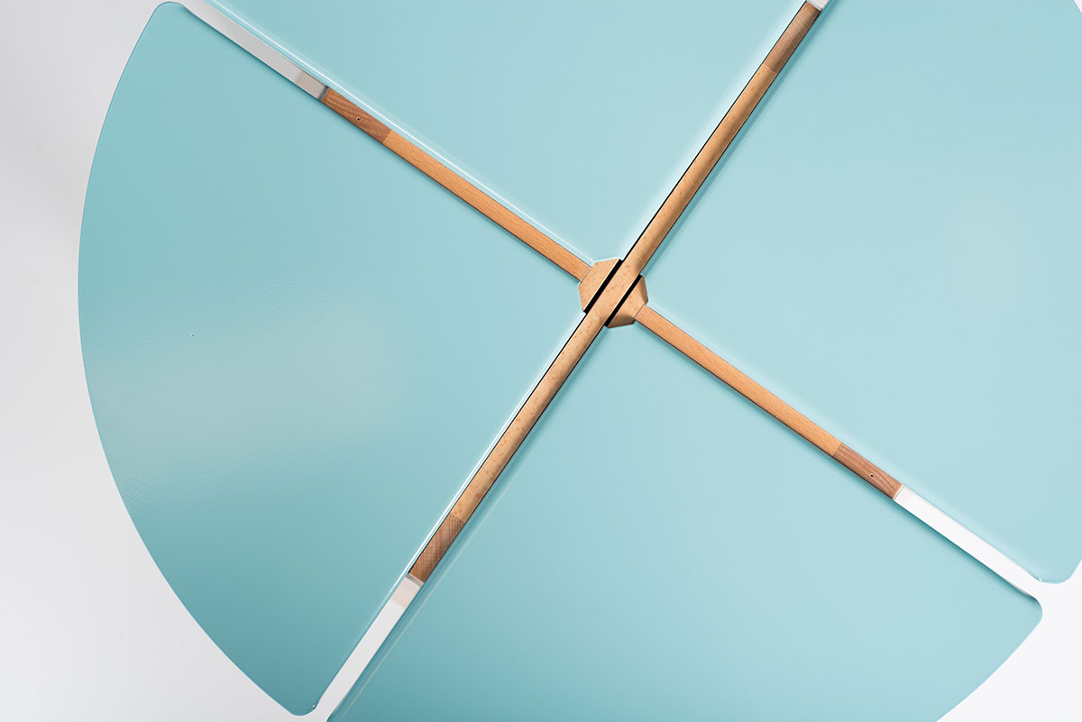 Close-up of wooden chopsticks crossing on a light blue surface.