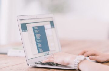 Person typing code on a laptop keyboard.
