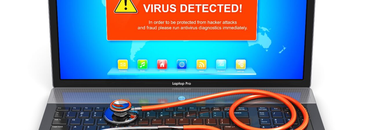 Laptop with virus warning and a stethoscope on keyboard.